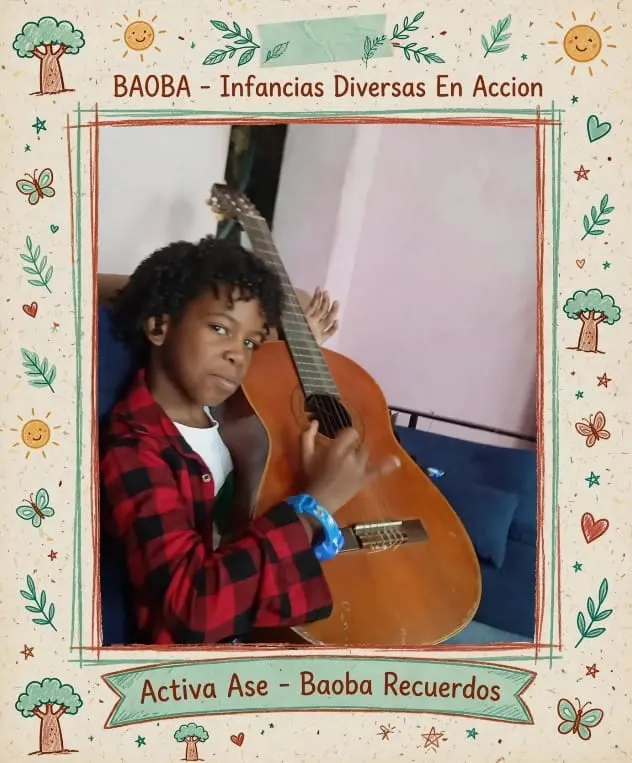 Un niño sentado en un sofá sostiene una guitarra casi tan grande como él y mira a la cámara.